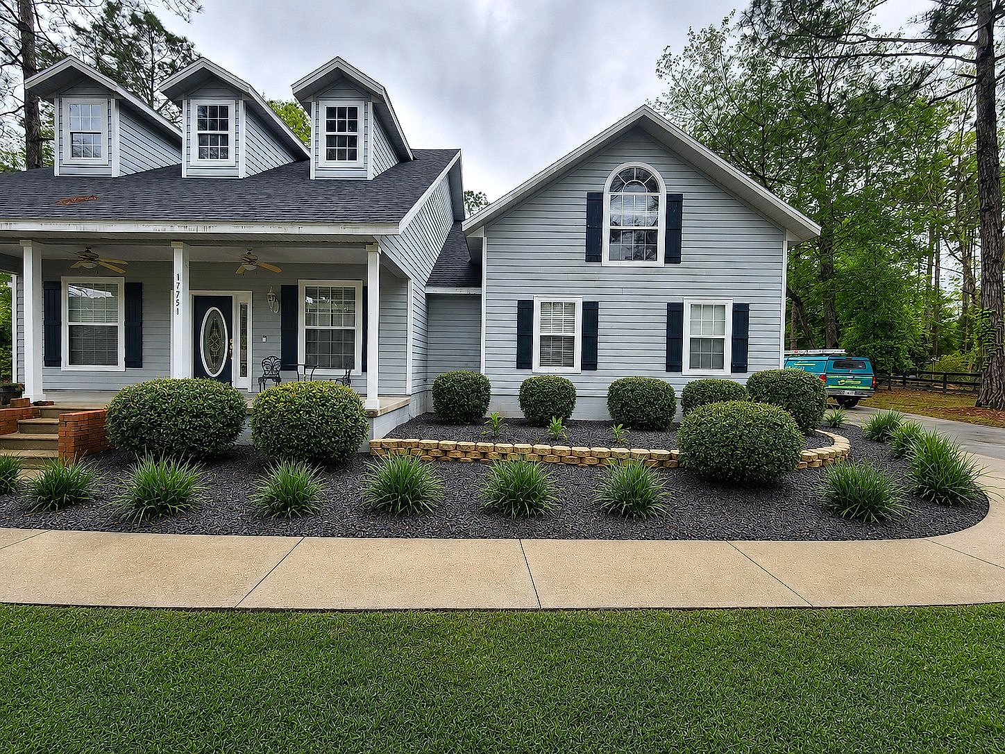 Finished landscape design and installation by Premier Lawn Care: trimmed shrubs, fresh mulch beds, and a stone border