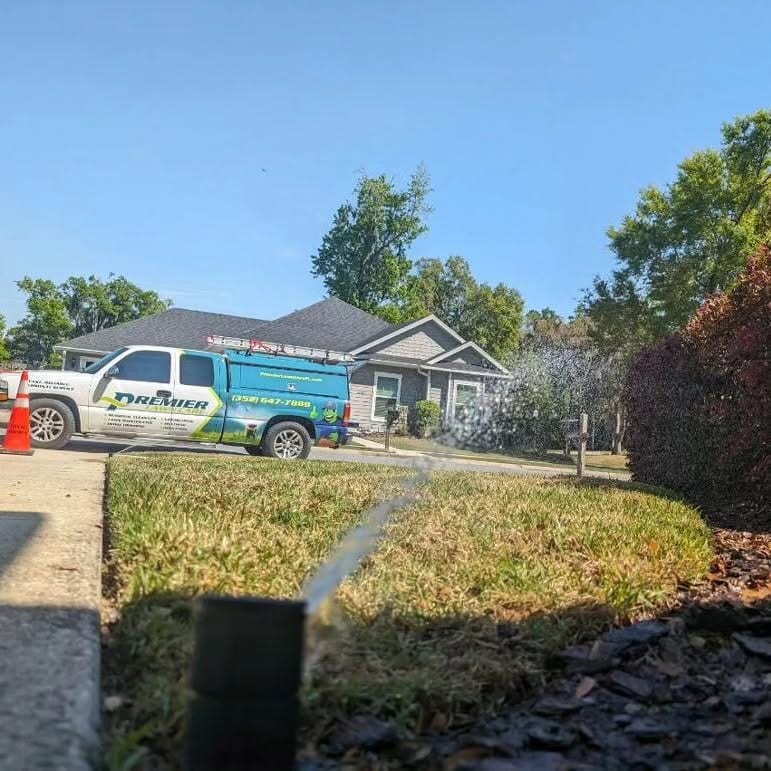 Irrigation sprinkler heads actively watering a lush green lawn