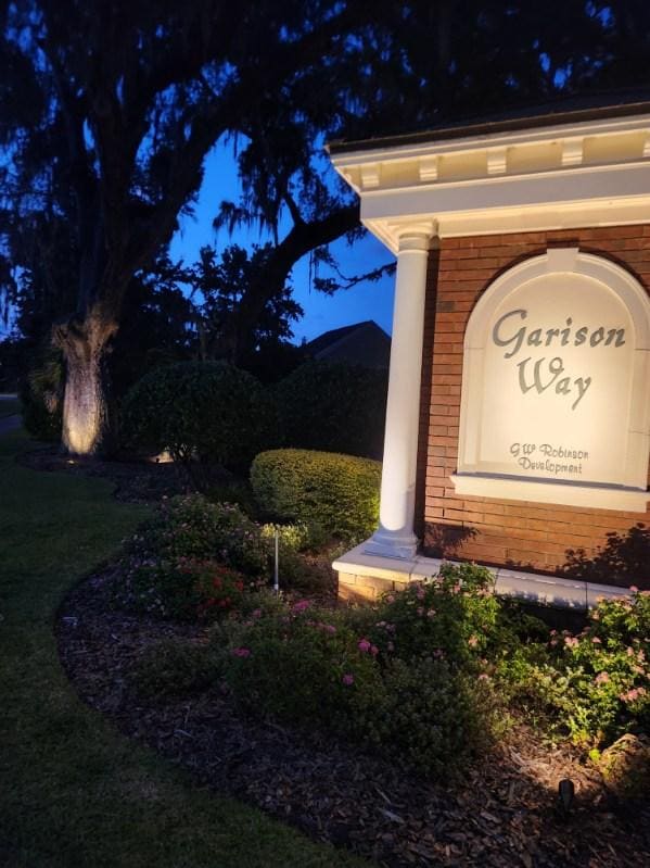 An illuminated community entrance sign with landscape lighting