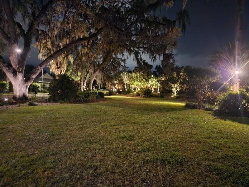 A lawn and walkway illuminated with landscape lighting at night