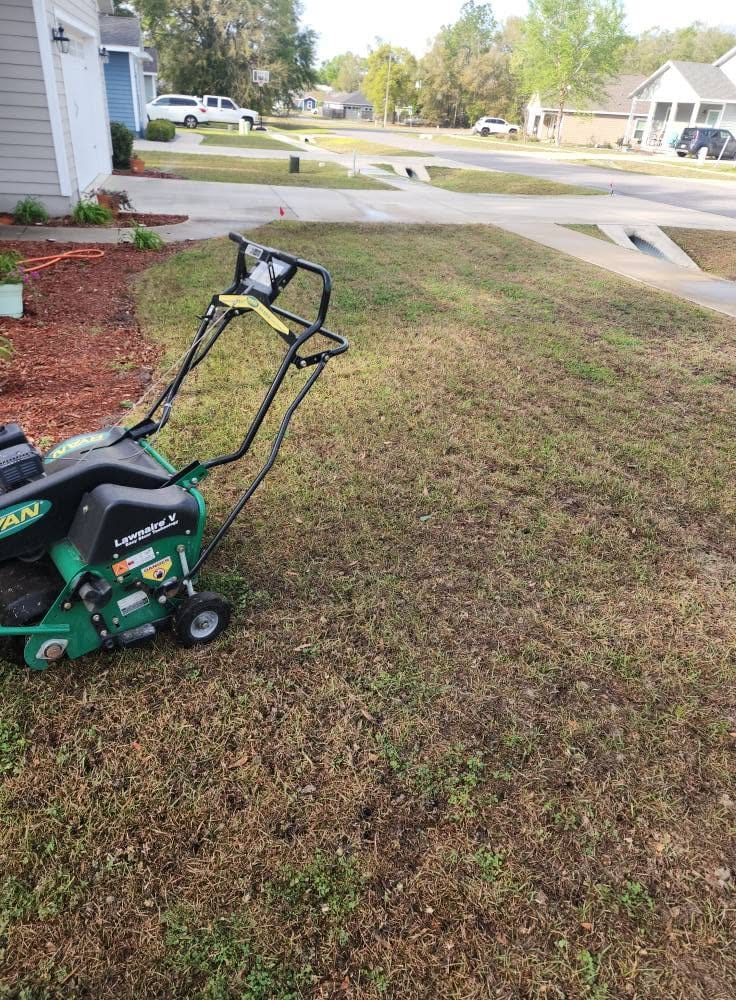A core aeration machine on a lawn being aerated